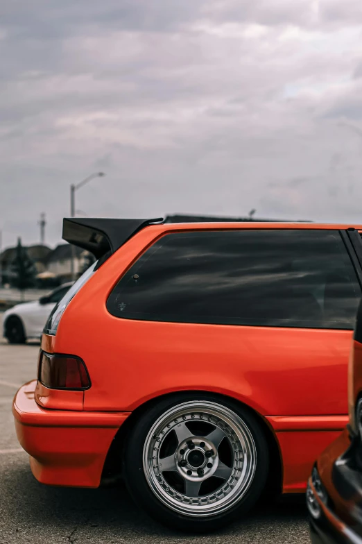 the back end of an orange, four - door car