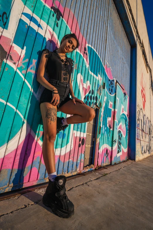 a woman standing in front of graffiti covered wall