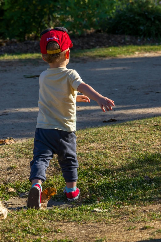 a little boy with a hat looking up at soing