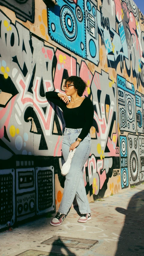 a  walking next to a graffiti covered wall