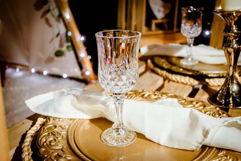 glasses sitting on top of a table with gold plates