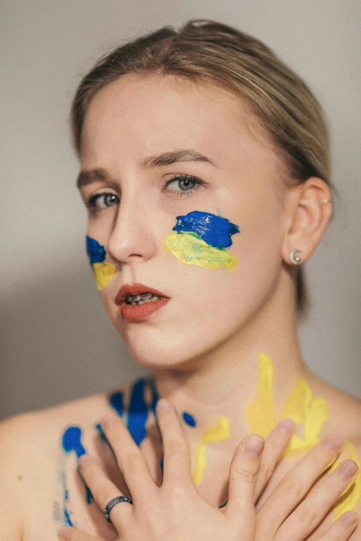 woman with yellow and blue paint painted on her face