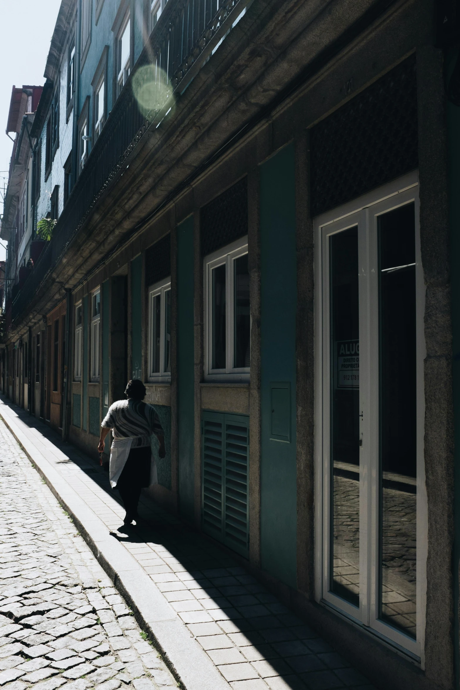 a person walking down the street with their back to a building