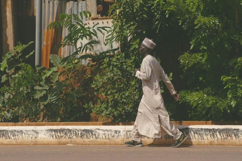 a man walking on a street with a white outfit