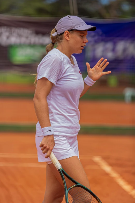 a woman is holding a tennis racquet on a court