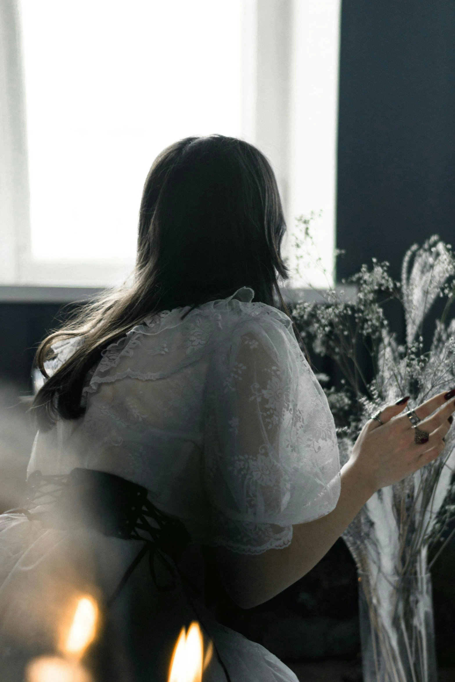 a girl looking at a bouquet that has been placed next to her