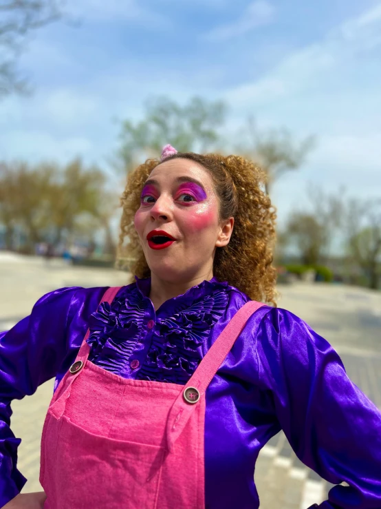 a woman in purple with face paint wearing an apron