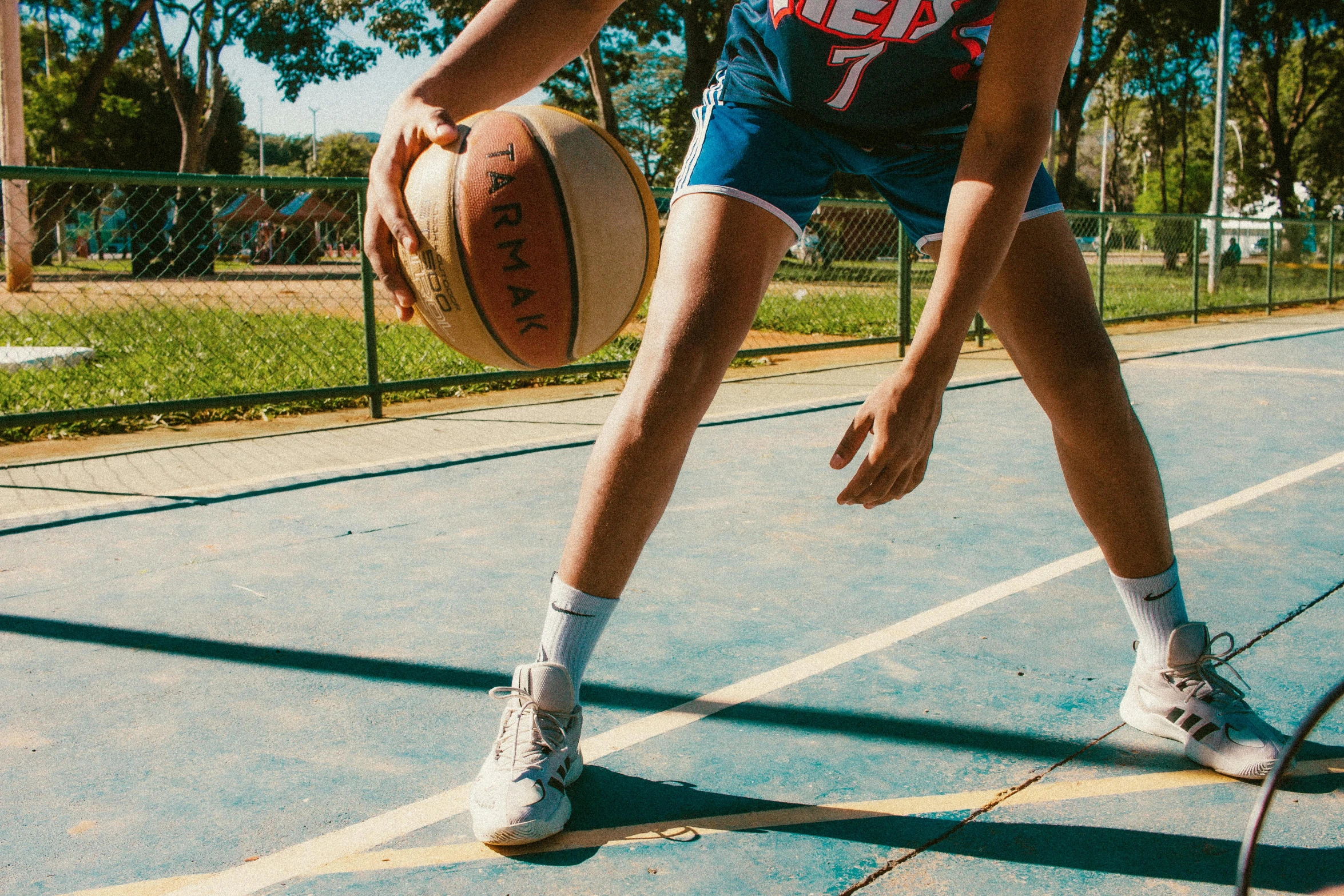 a man is holding a basketball in his left hand