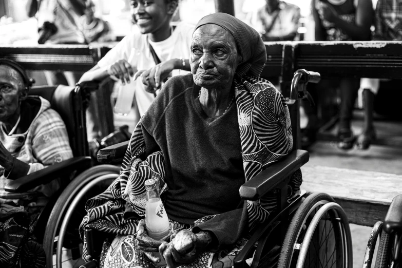 the elderly women are being assisted in wheel chair