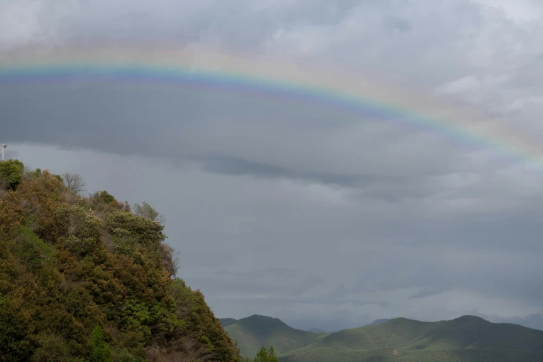 the rainbow is very brightly visible over the valley