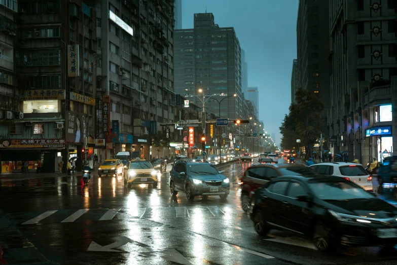 cars drive down the road on a rainy night