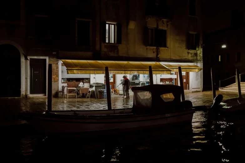 a boat floating on top of a river next to a building