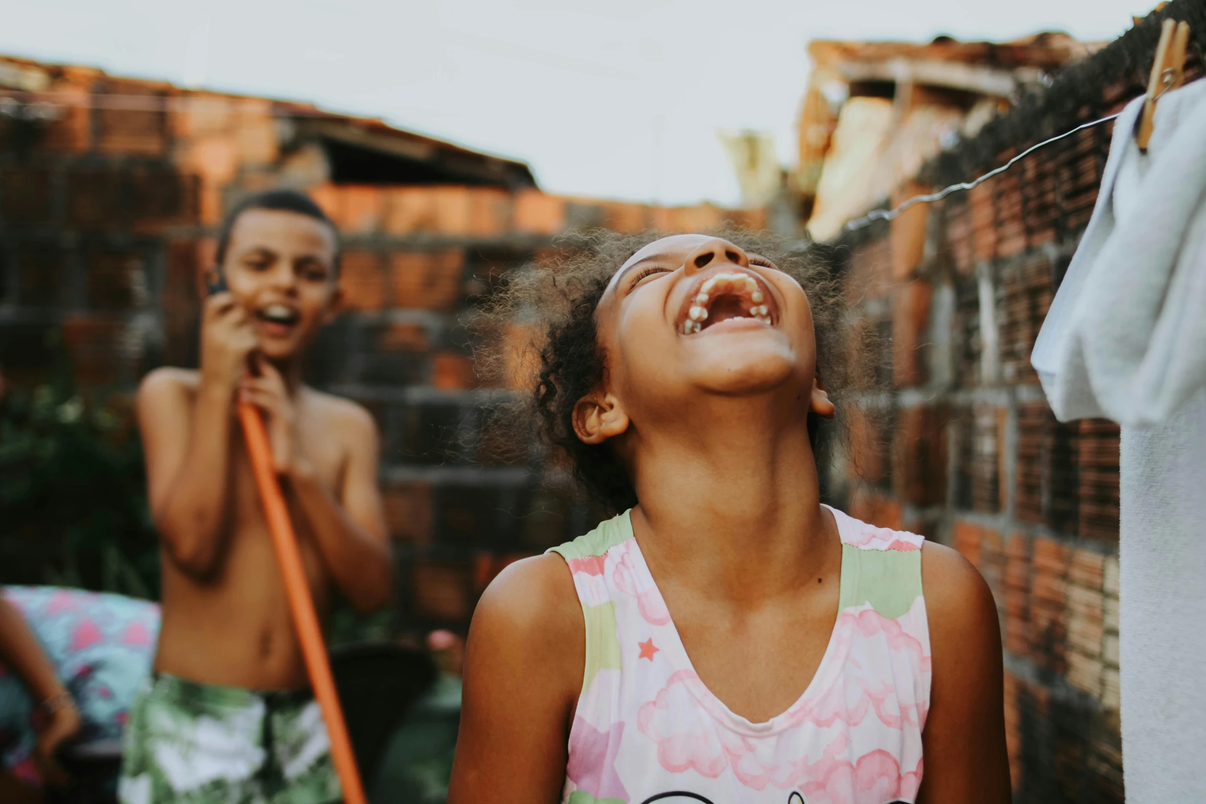 two young children with one in the air laughing