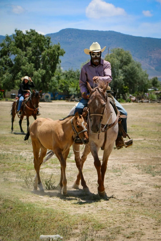 three people are riding on horses in the field