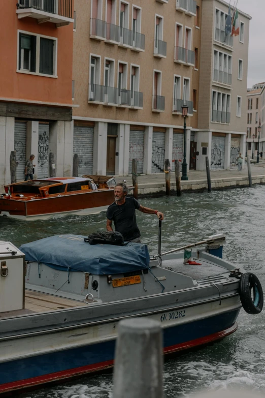 a man on a small boat in a canal