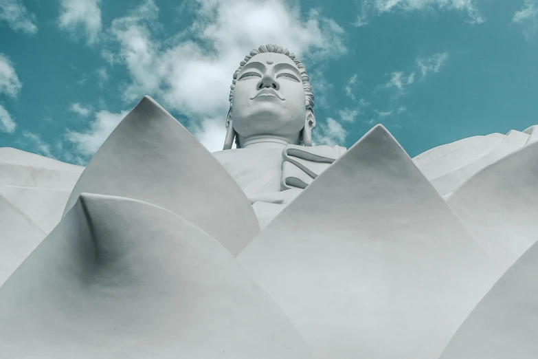 the head of a buddha statue sitting on top of clouds