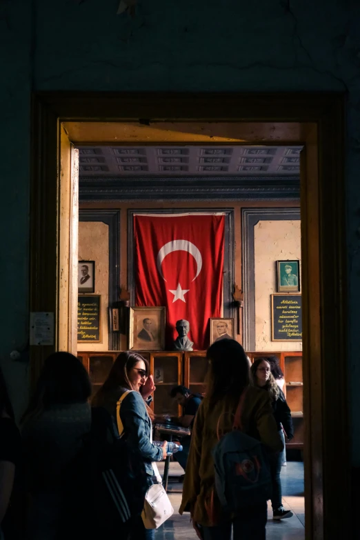 some people are walking through a doorway towards a statue