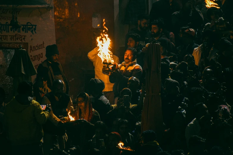 a person standing on fire with a lot of people watching