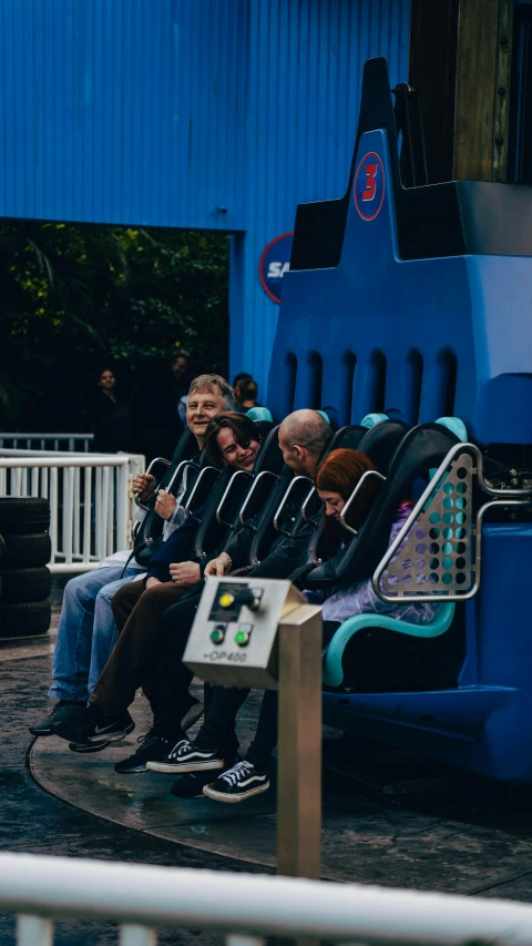 some people sitting on a blue chair outside