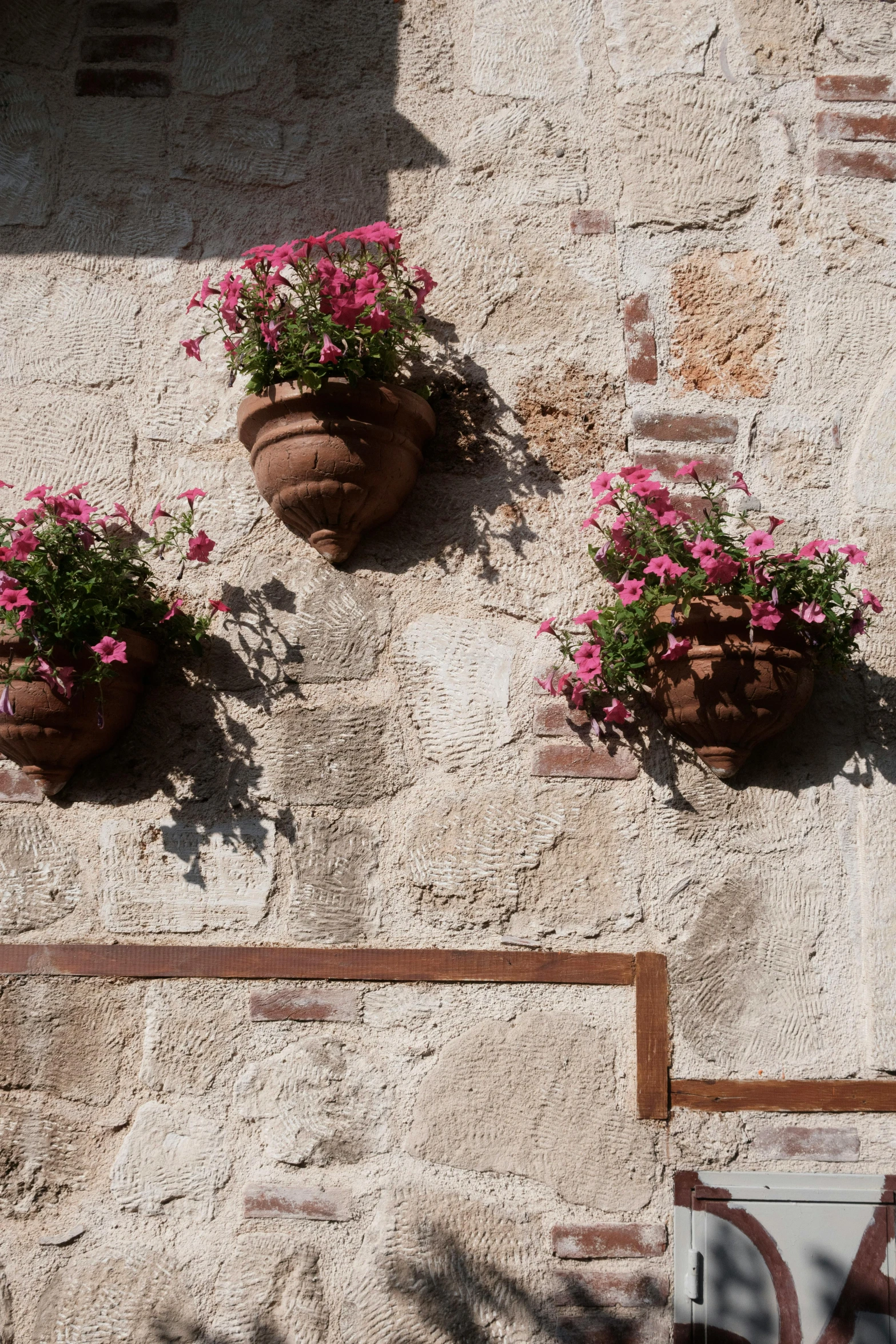 three flower pots on a wall are on the wall
