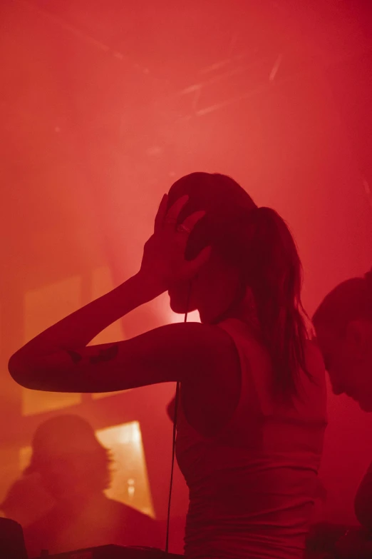 a female in headphones and a red background