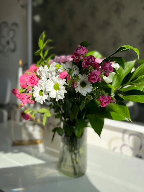a vase filled with pink and white flowers on a table