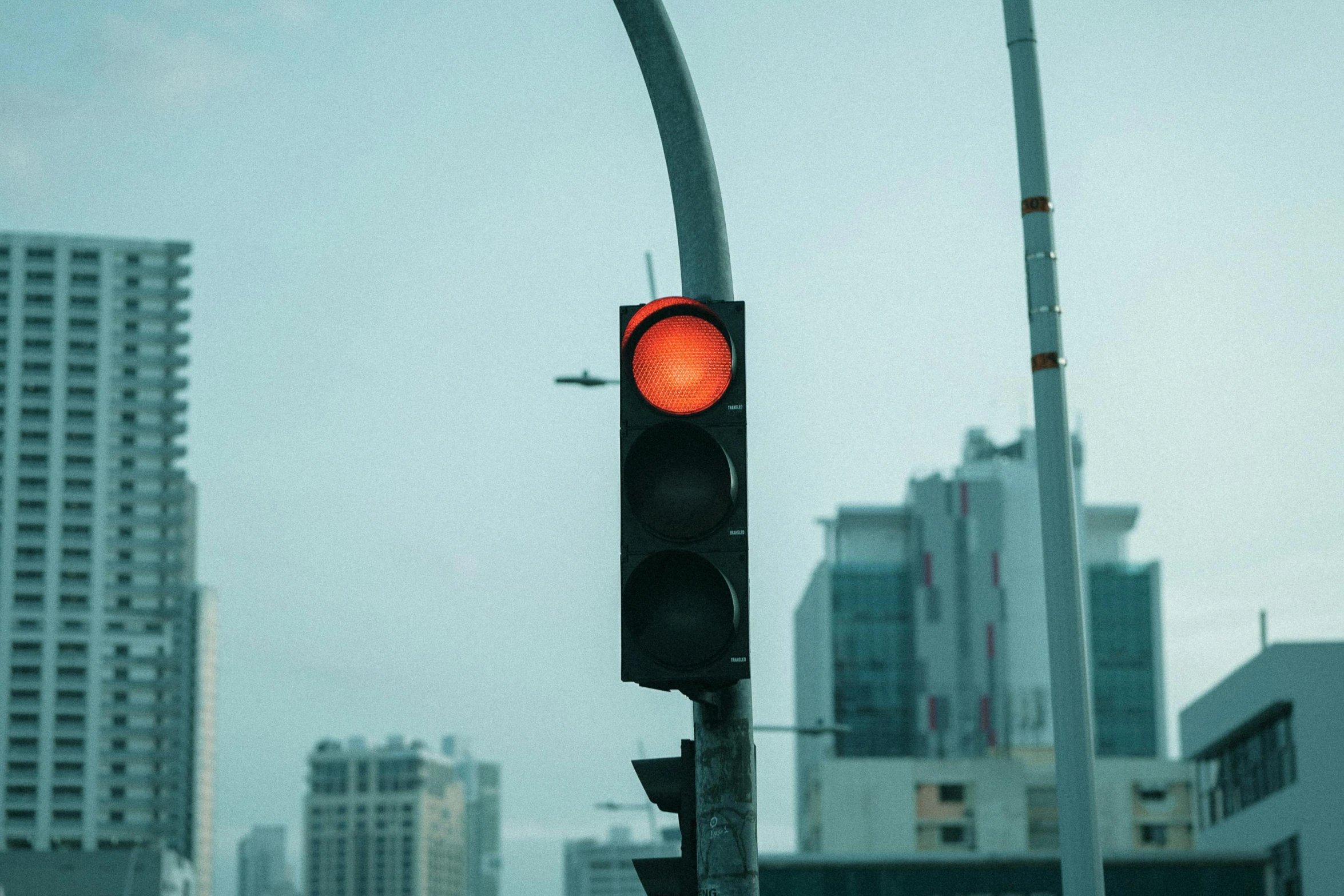 a traffic light that is on with the sun coming down