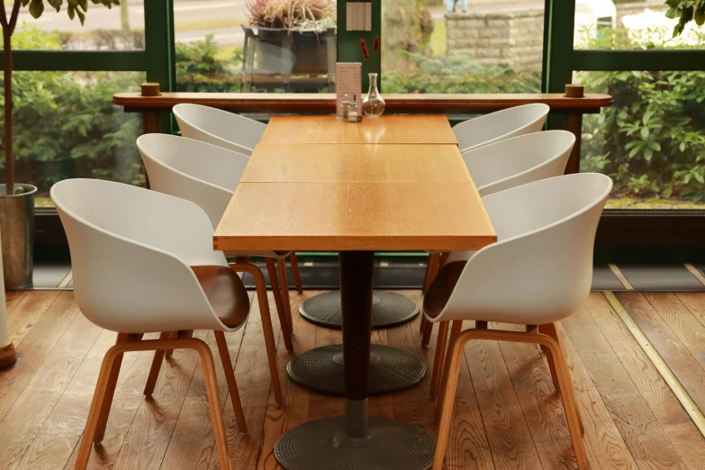 a wooden table with white chairs around it