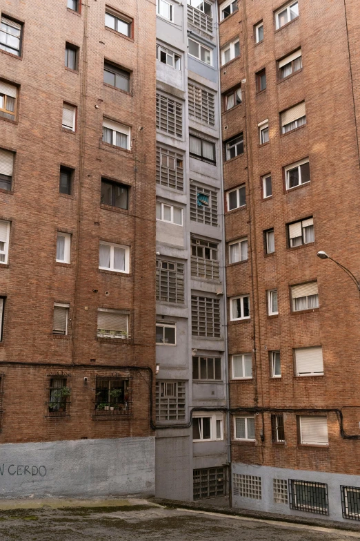 two tall brown buildings with windows one high