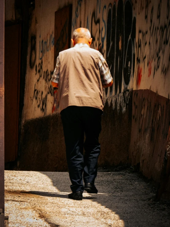 a person walking down a street near graffiti
