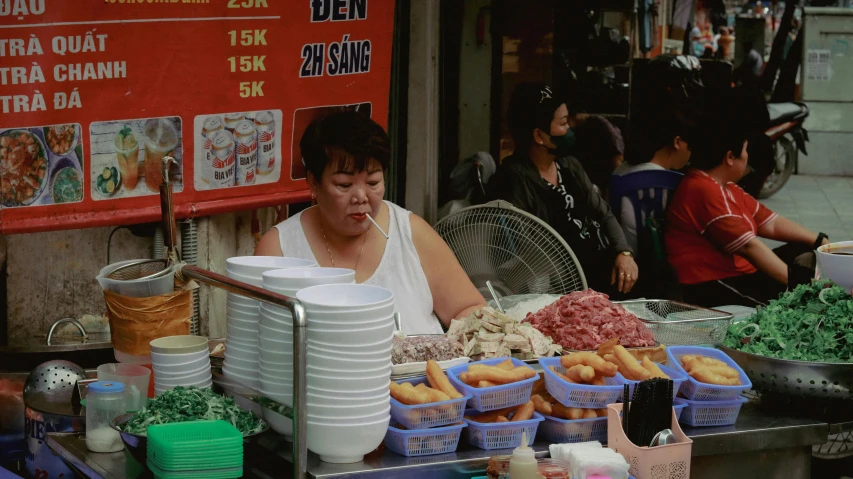 a man standing behind a counter filled with dishes of food