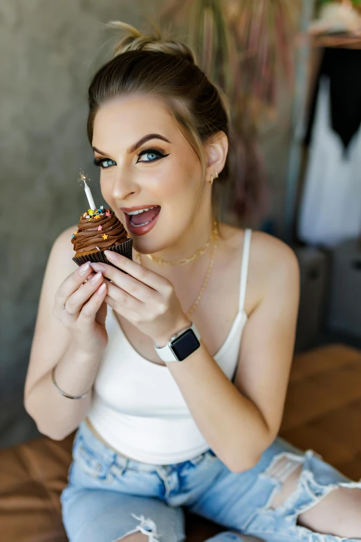 a woman in a white top with a piece of cake