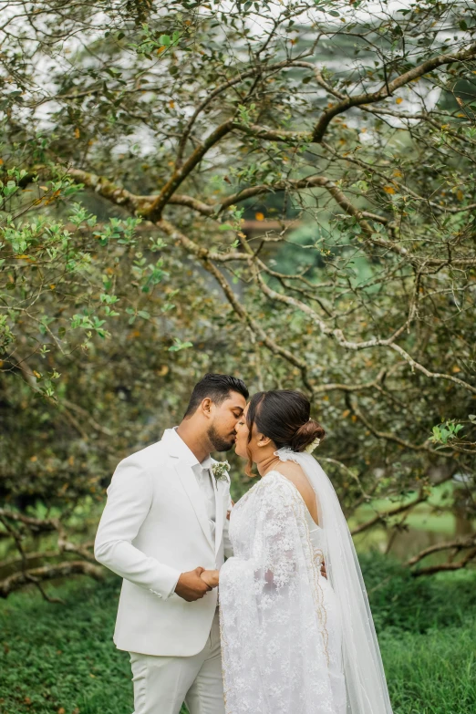 a couple is getting married in front of a tree