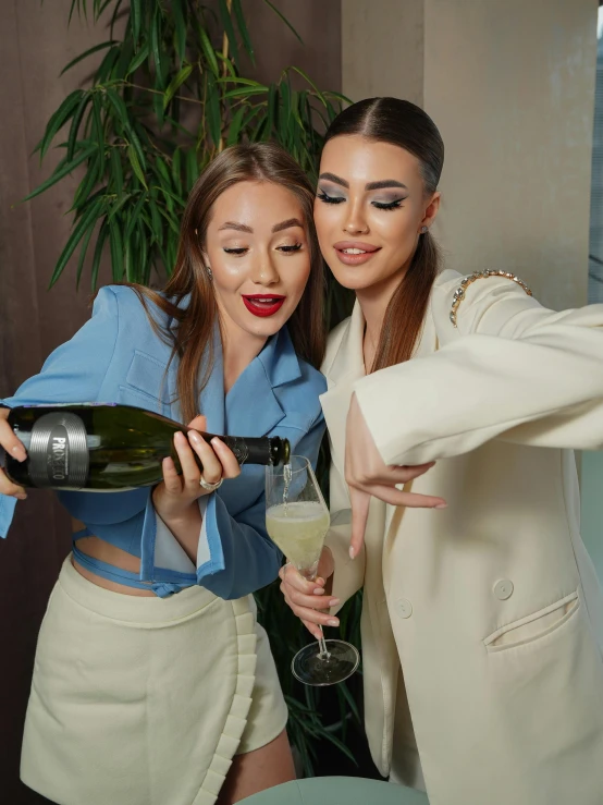 two ladies with glasses are holding wine glasses