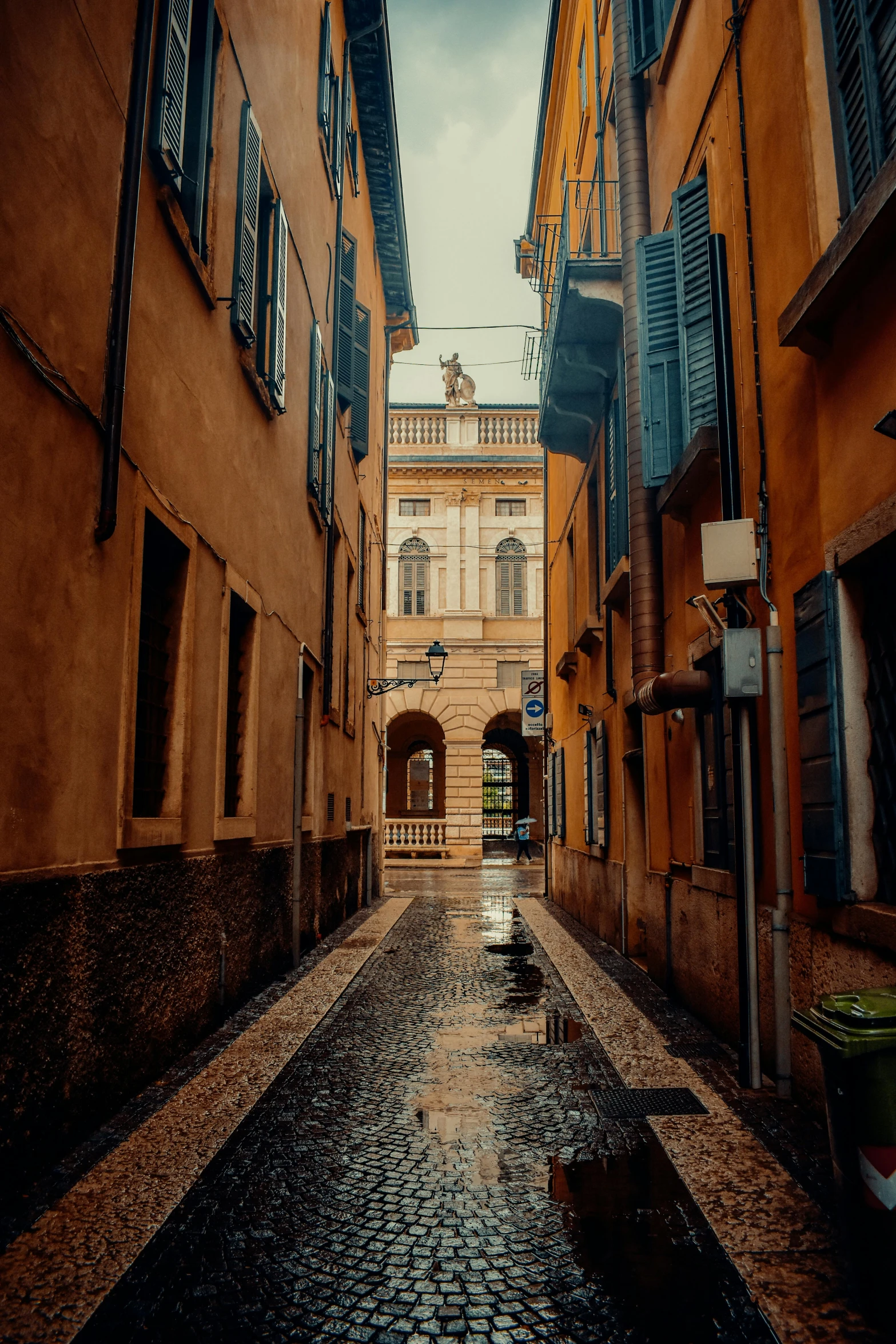 there is a rainy sidewalk between two buildings