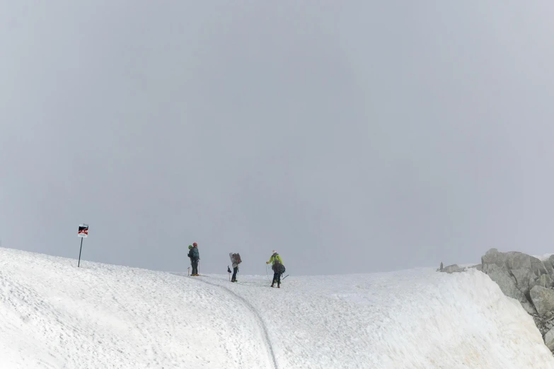 people are snow boarding down a hill and watching the flag