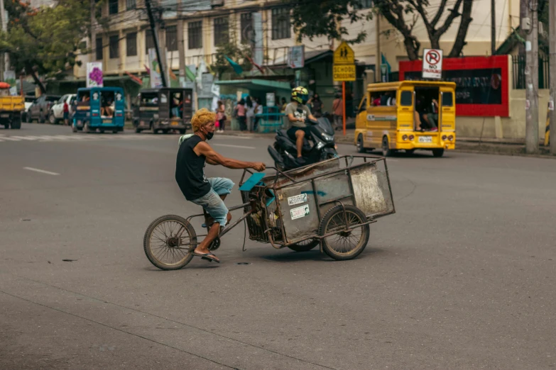 the man is riding his bike carrying a cage