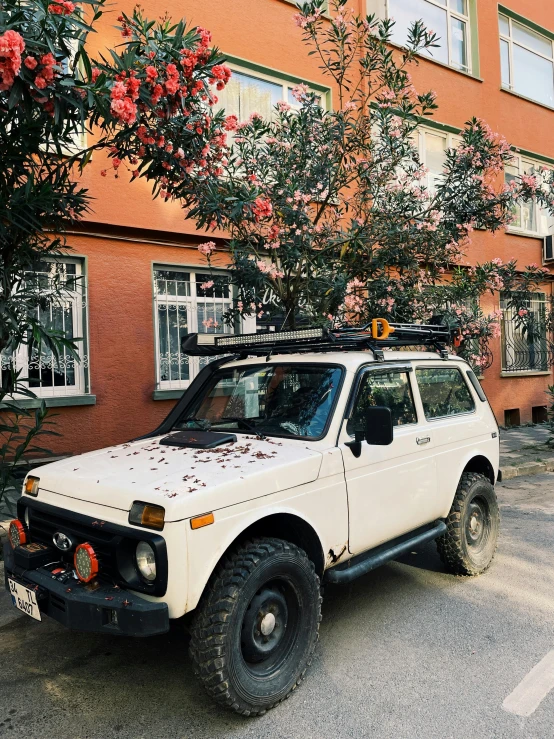 a white vehicle is parked near some tall buildings