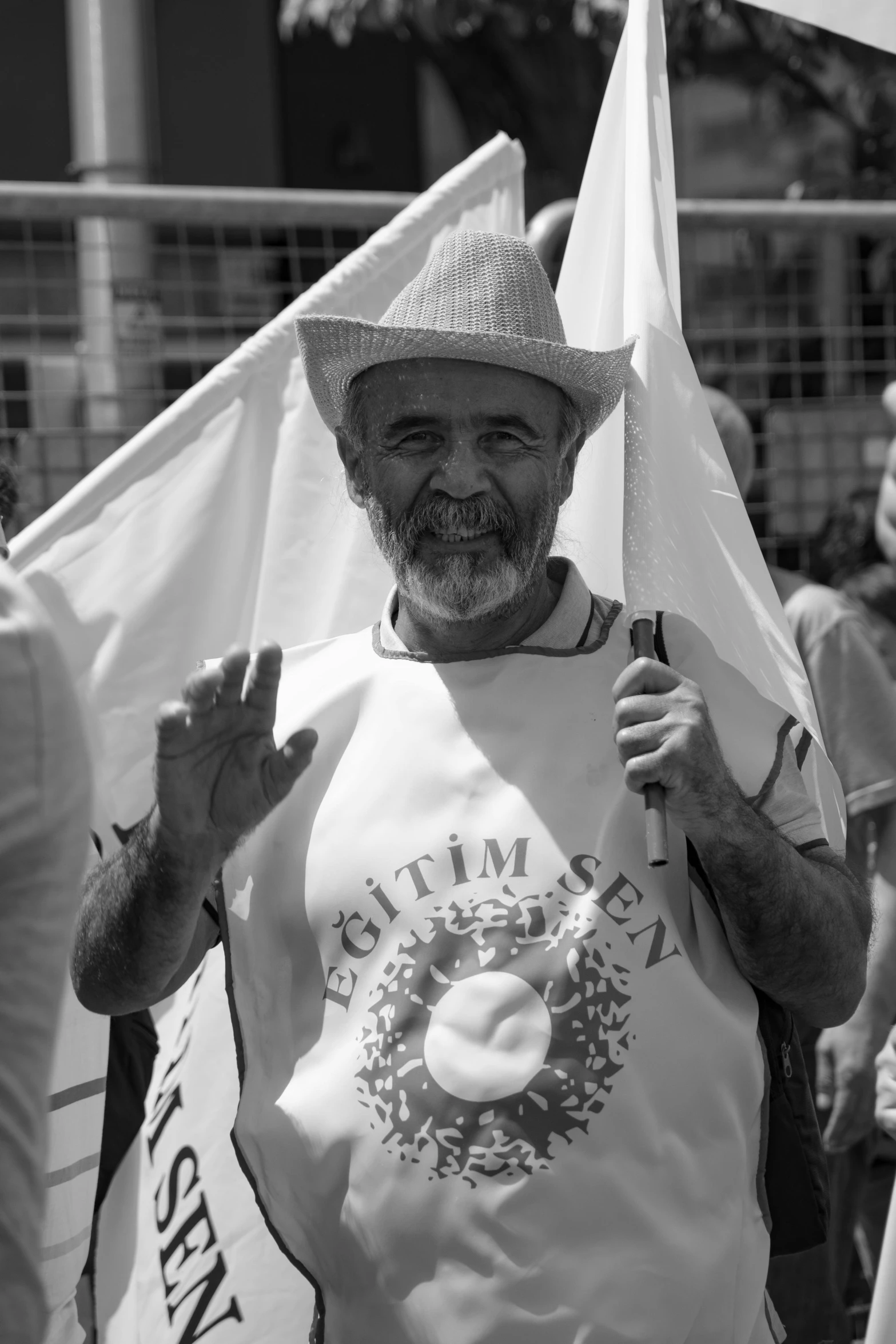 black and white po of an older man holding a plate and a flag