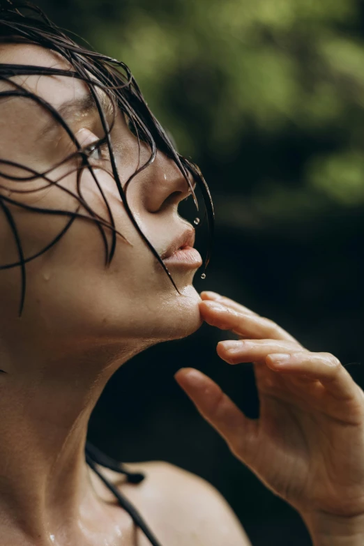 a woman in wet hair standing outside with her hand to her mouth