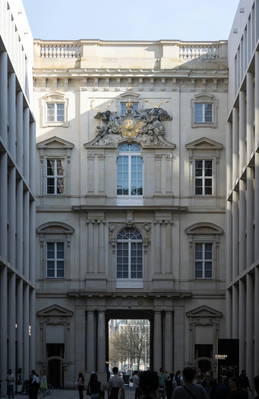 people stand in front of the building with stone pillars