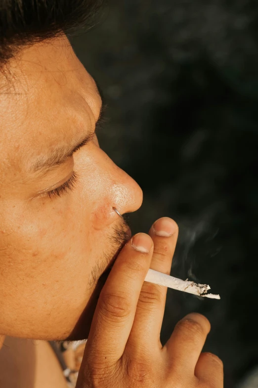 a man smoking a cigarette with an intense look on his face