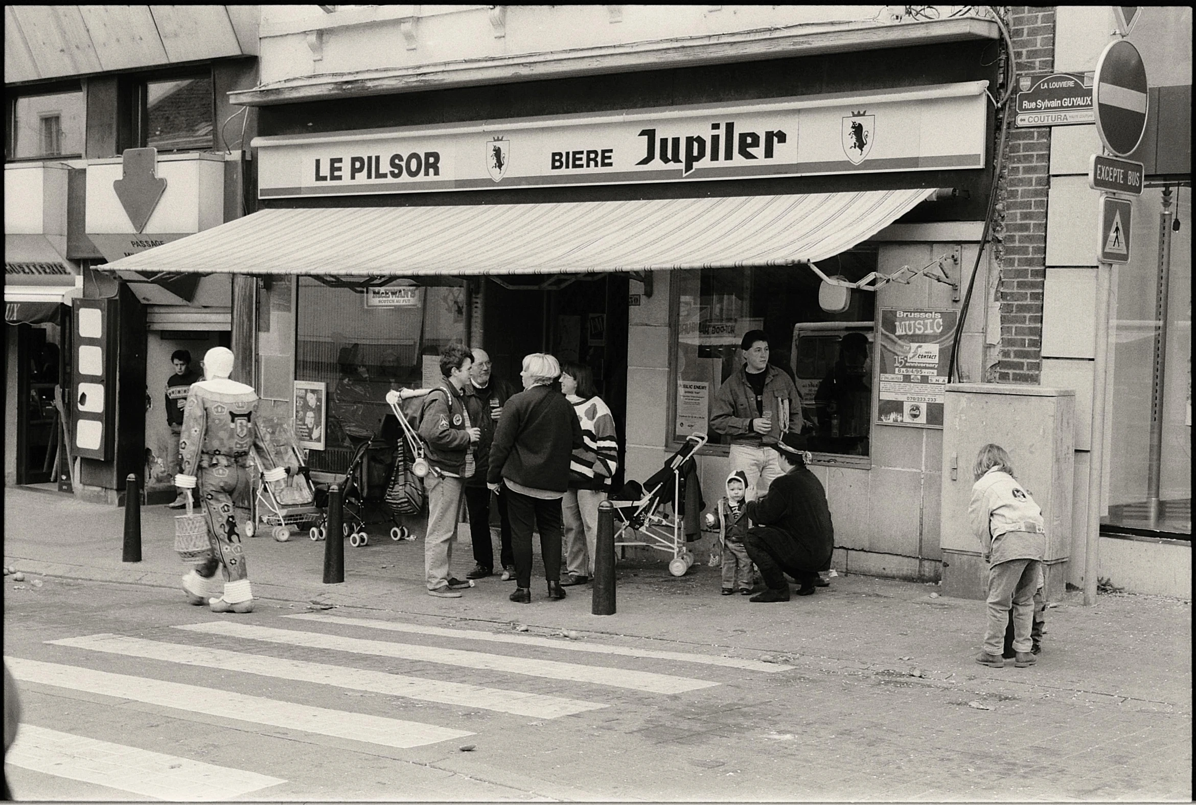 several children are sitting outside of a shop in the street