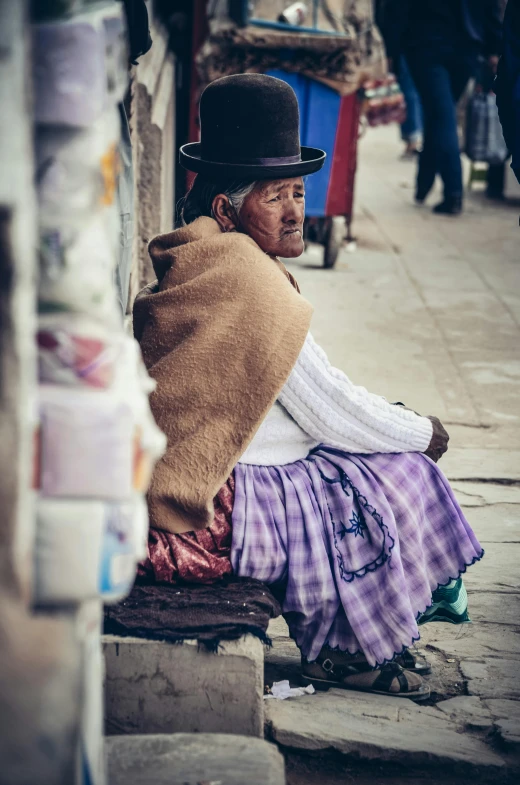 an elderly woman sitting down in the street