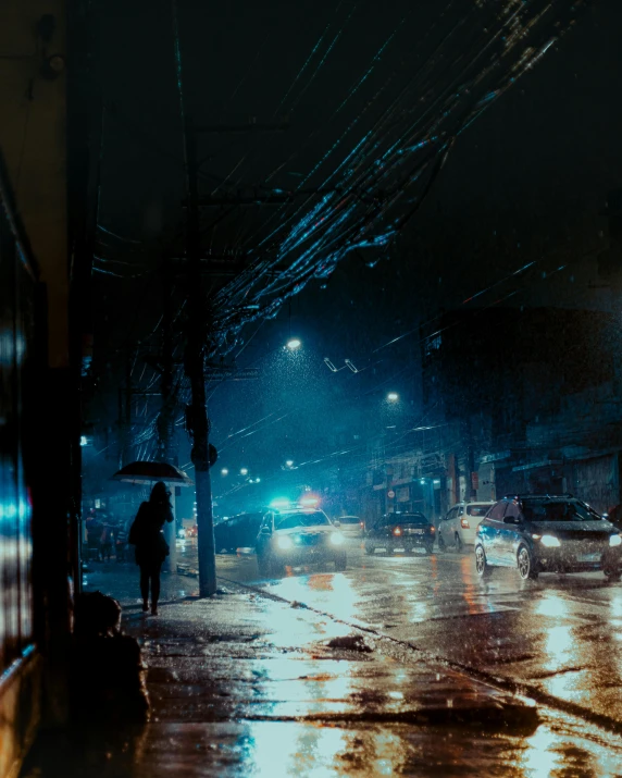 people walking down the street at night under an umbrella