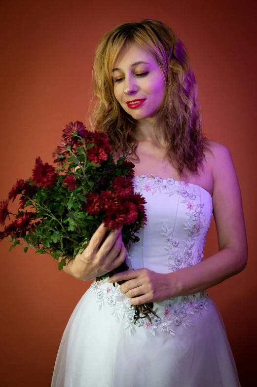 there is a woman holding red flowers and posing for a picture