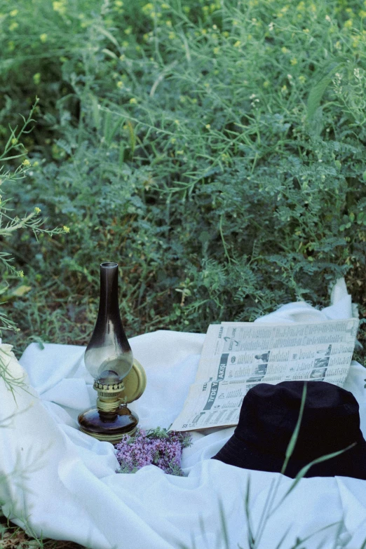 a hat and some books on a cloth in the grass