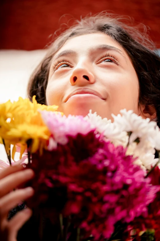 a woman holds some different flowers in her hands