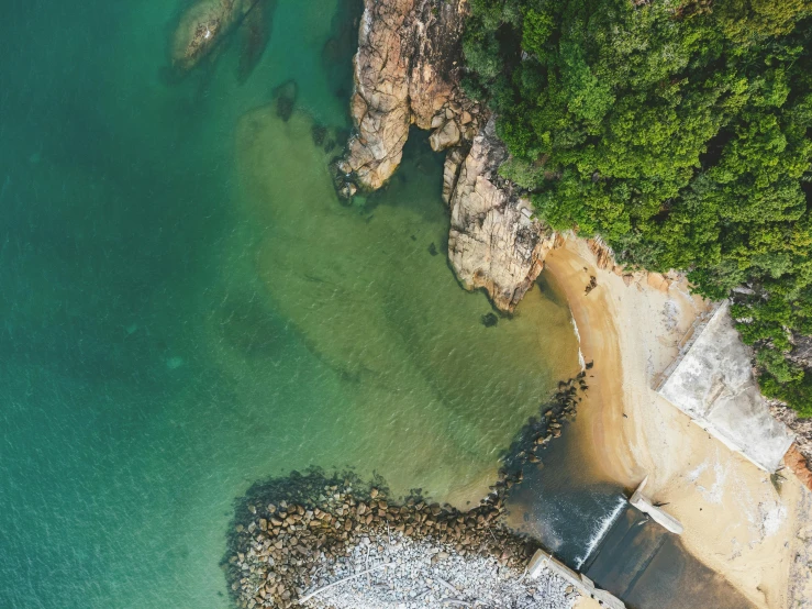 an aerial view of a sandy beach and clear water