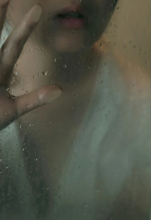 a woman looks out the window, while her hand is next to her face